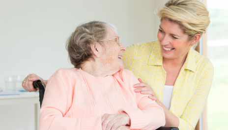 woman smiling at mom in sitting in a wheelchair